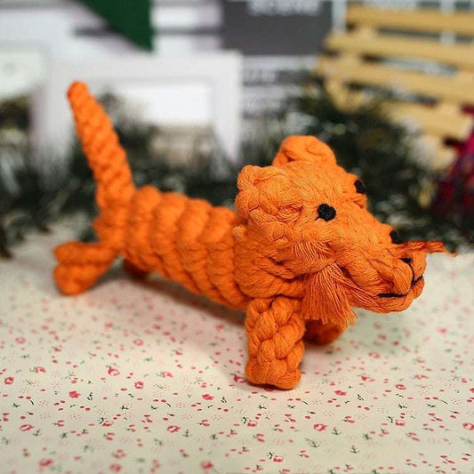 Orange knitted toy resembling a snake on a floral-patterned surface