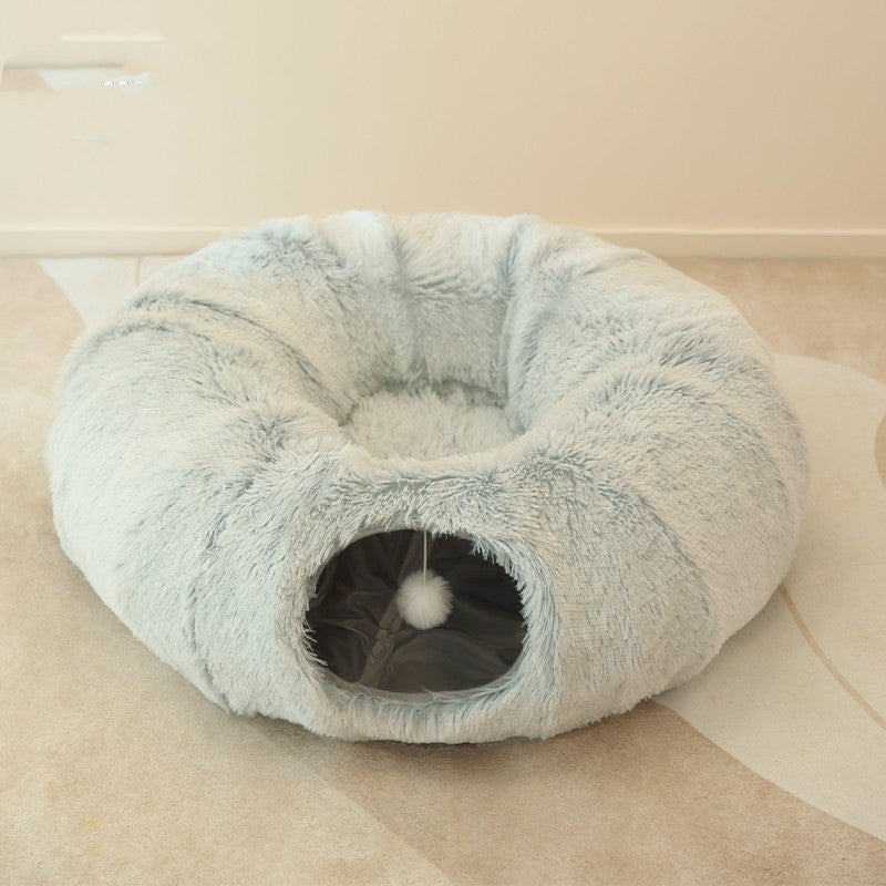 Fluffy pet bed with a pom-pom on a beige carpet