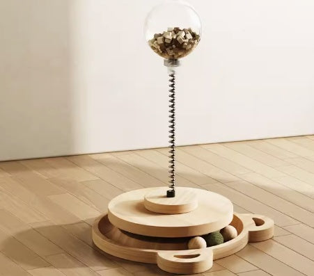 Wooden puzzle toy with a spring-loaded ball on a wooden floor