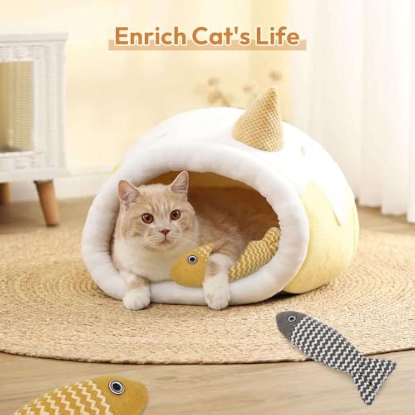 Cat lying in a white and yellow cat house with fish-shaped toys on a wooden floor.