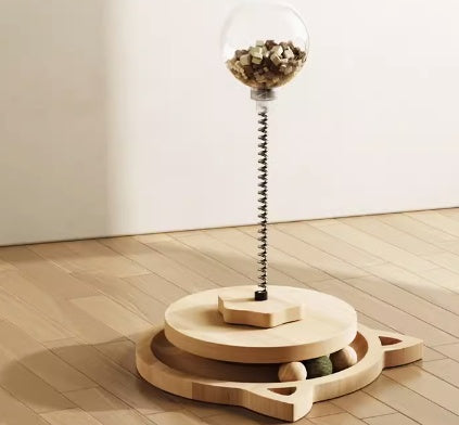 Wooden sculpture with a glass sphere containing coins on a wooden floor.
