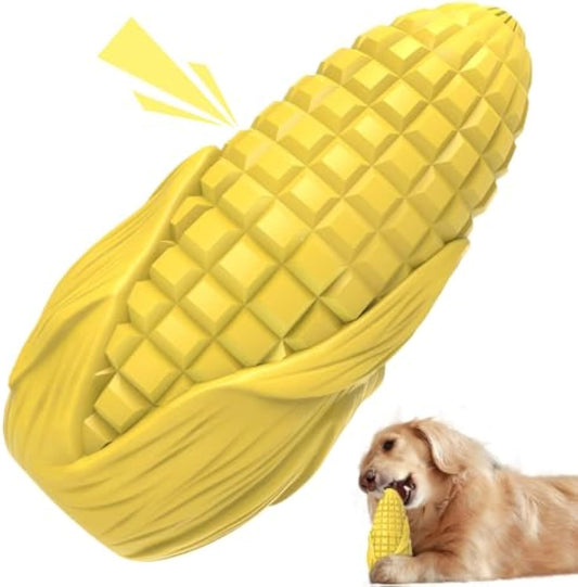 Yellow corn-shaped dog toy with a dog chewing on it.