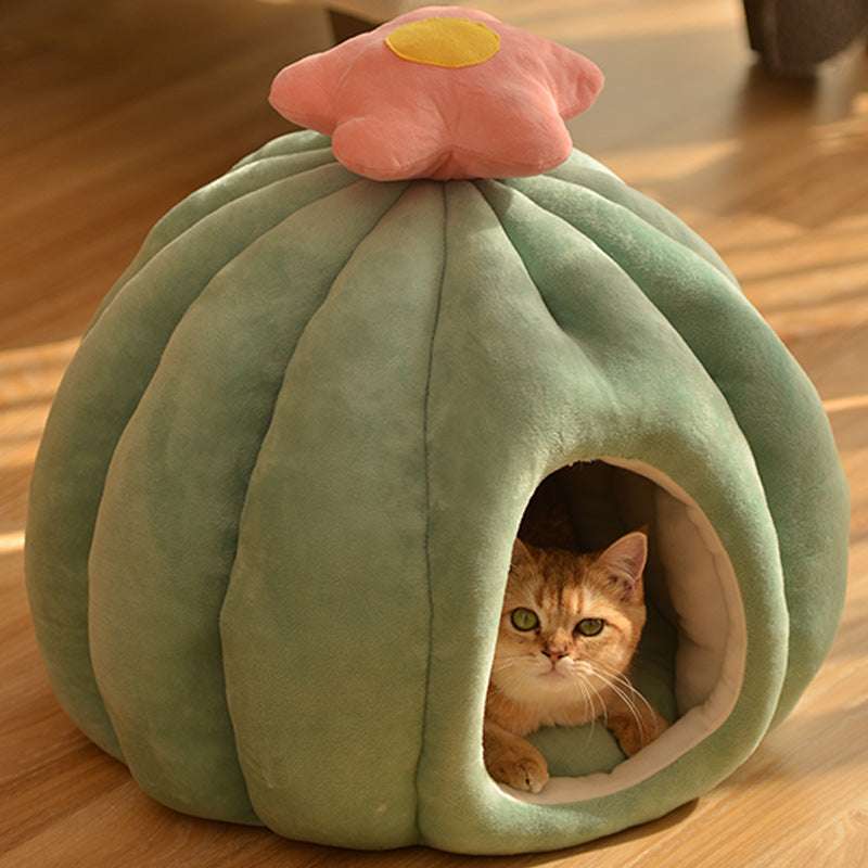 Cat peeking out from a green pet bed shaped like a flower on a wooden floor.